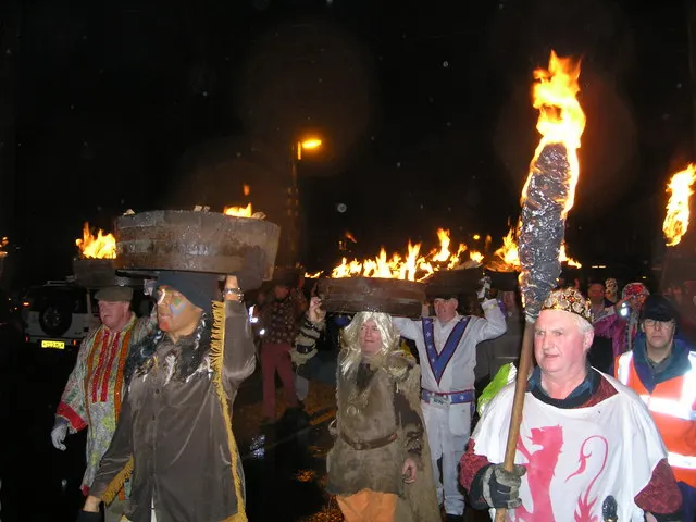 Guisers in costume carry blazing barrels of tar on their heads through a crowd in Allendale Town on New Year's Eve.