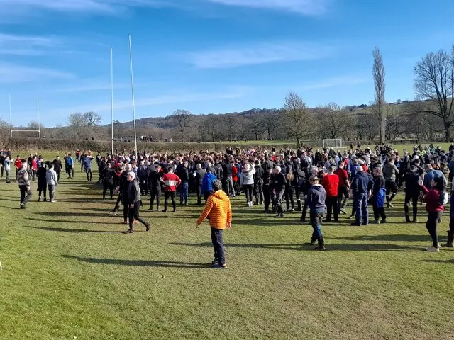 Hundreds of players pack into a scrum, known as the hug, on a Derbyshire field during Royal Shrovetide Football at Ashbourne.