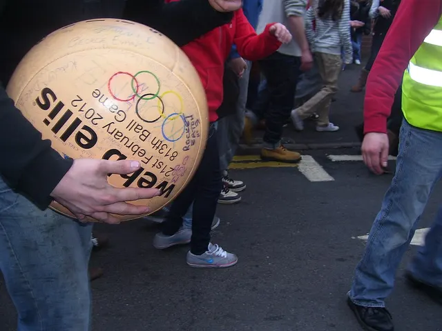 A player holds the specially made, hand-painted Atherstone Ball Game ball, signed and dated, amid a scrum on Long Street.