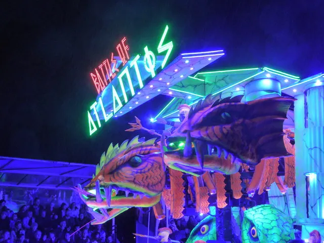 The illuminated 'Battle of Atlantos' dragon float lights up the night at Bridgwater Carnival, watched by crowds.