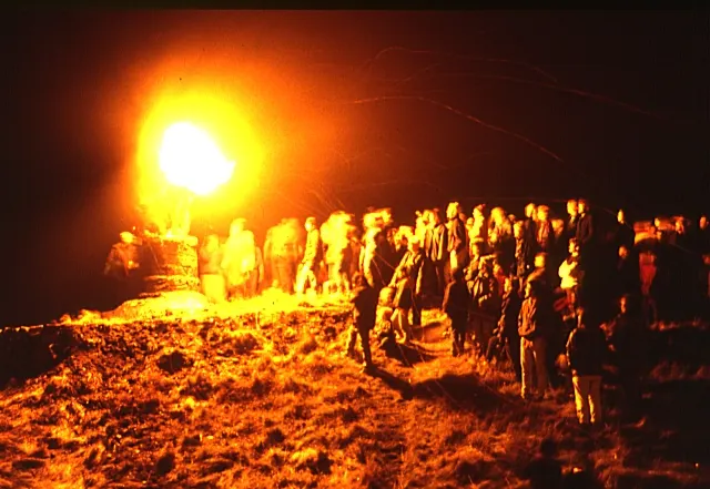 The Clavie blazes on its post atop Doorie Hill as a crowd looks on in Burghead.