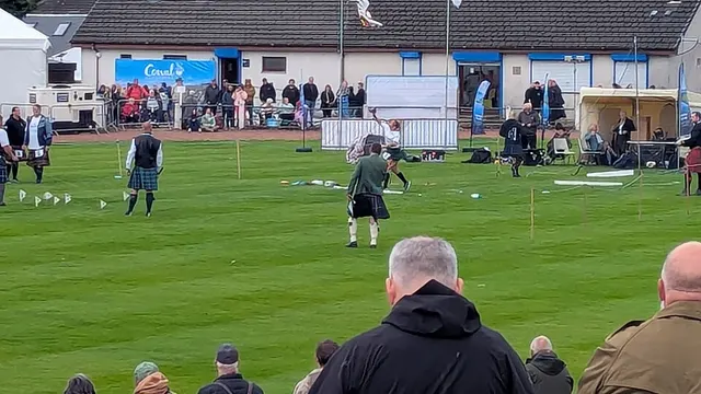 A competitor prepares to throw a weight on the games field at Dunoon Stadium as spectators watch from the stand during the Cowal Highland Gathering.