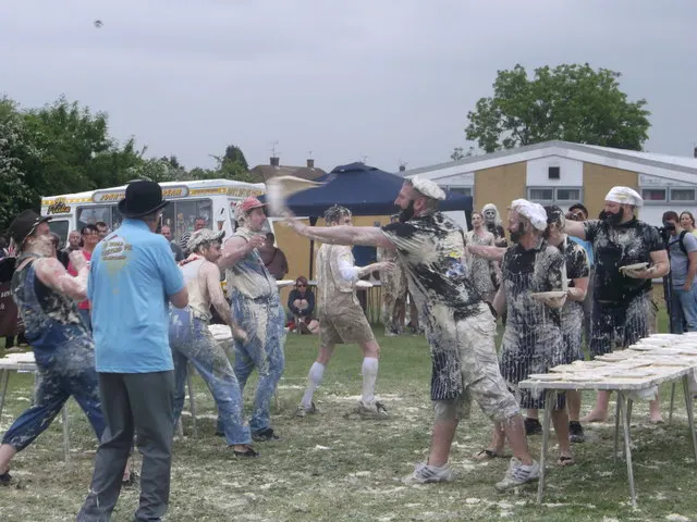 A custard pie flies through the air as costumed teams pelt each other beside tables of pies at the World Custard Pie Championship.