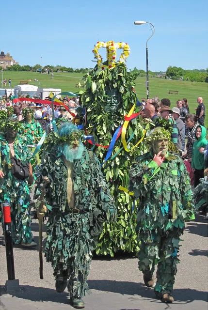 Jack, covered head to foot in leaves, is led through the crowd during the Hastings Jack in the Green procession.