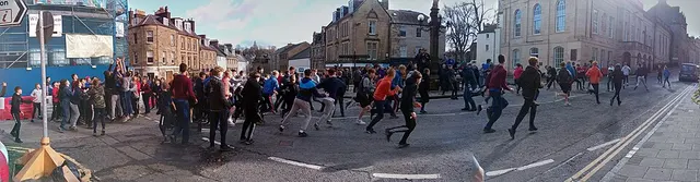 Players run and scramble for the ba' across Jedburgh's market place, past the mercat cross, during the Ba' Game.