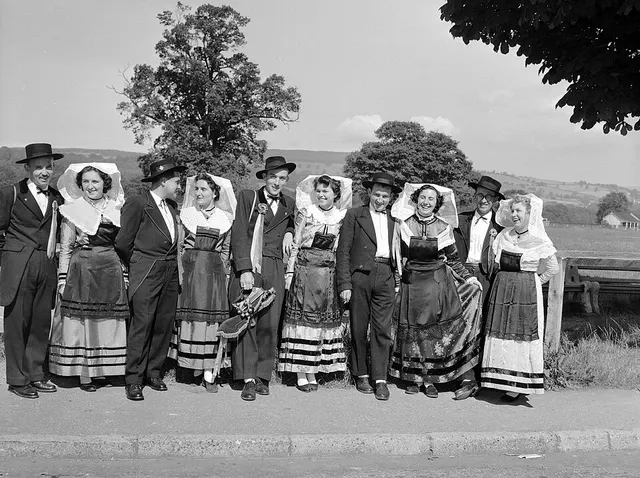 A line of competitors in national folk costume pose outdoors during the Llangollen International Musical Eisteddfod.