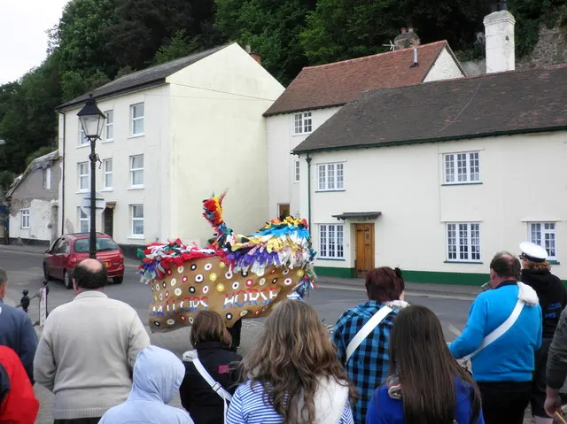 The ribboned, boat-shaped hobby horse heads down a street followed by onlookers during Minehead's May Day custom.