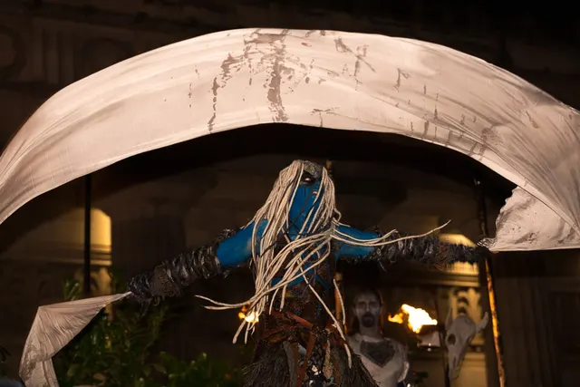 The Cailleach, the winter hag of the Samhuinn story, dances beneath a sweep of pale fabric at the Beltane Fire Society's Samhuinn