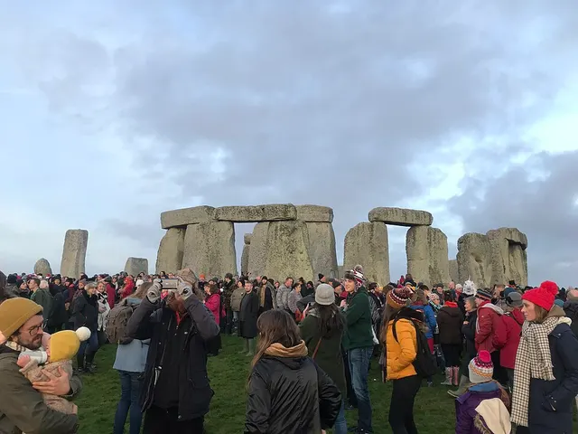 A large crowd gathers among the stones of Stonehenge at dawn for the winter solstice, when English Heritage opens the circle for one day of managed access.