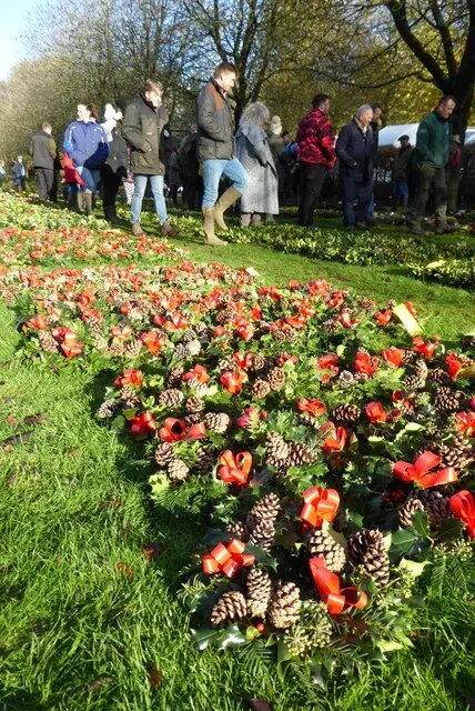 Rows of holly and mistletoe wreaths trimmed with red ribbon, laid out for the Tenbury Wells Christmas auction.