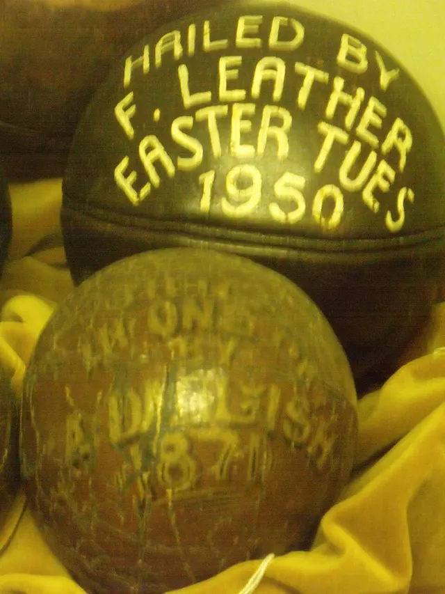 Two hand-made leather match balls from past Uppies and Downies games, each painted with the year it was hailed.