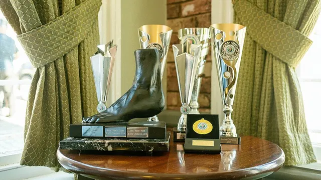 Toe wrestling trophies, including a boot-shaped cup, displayed at the World Toe Wrestling Championship.
