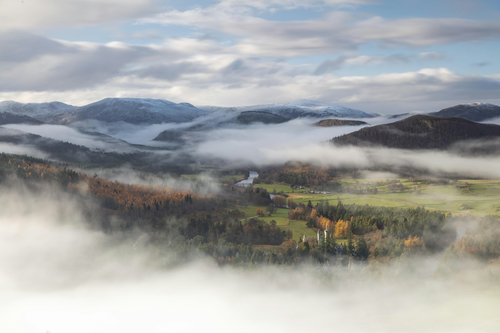 Photo of a scenic view of a valley with mountains in the background.