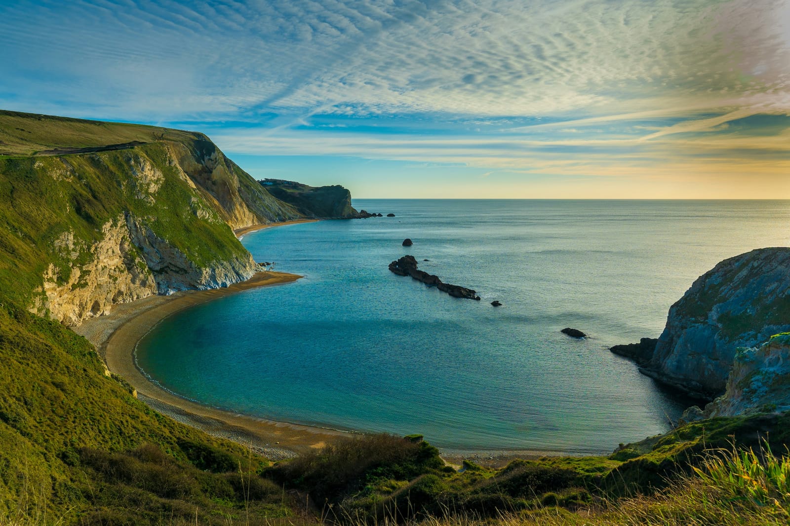 Photo of a turquoise bay on the Dorset coast near Lulworth at dawn.
