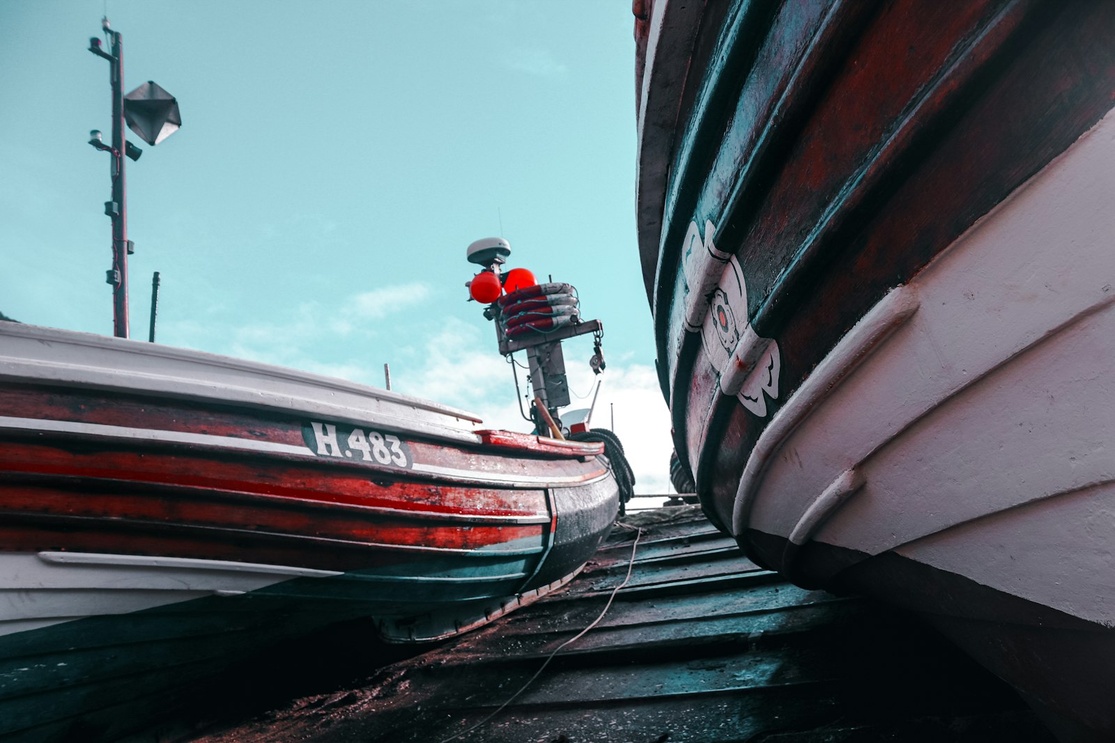Photo of red and white boat on dock during daytime.