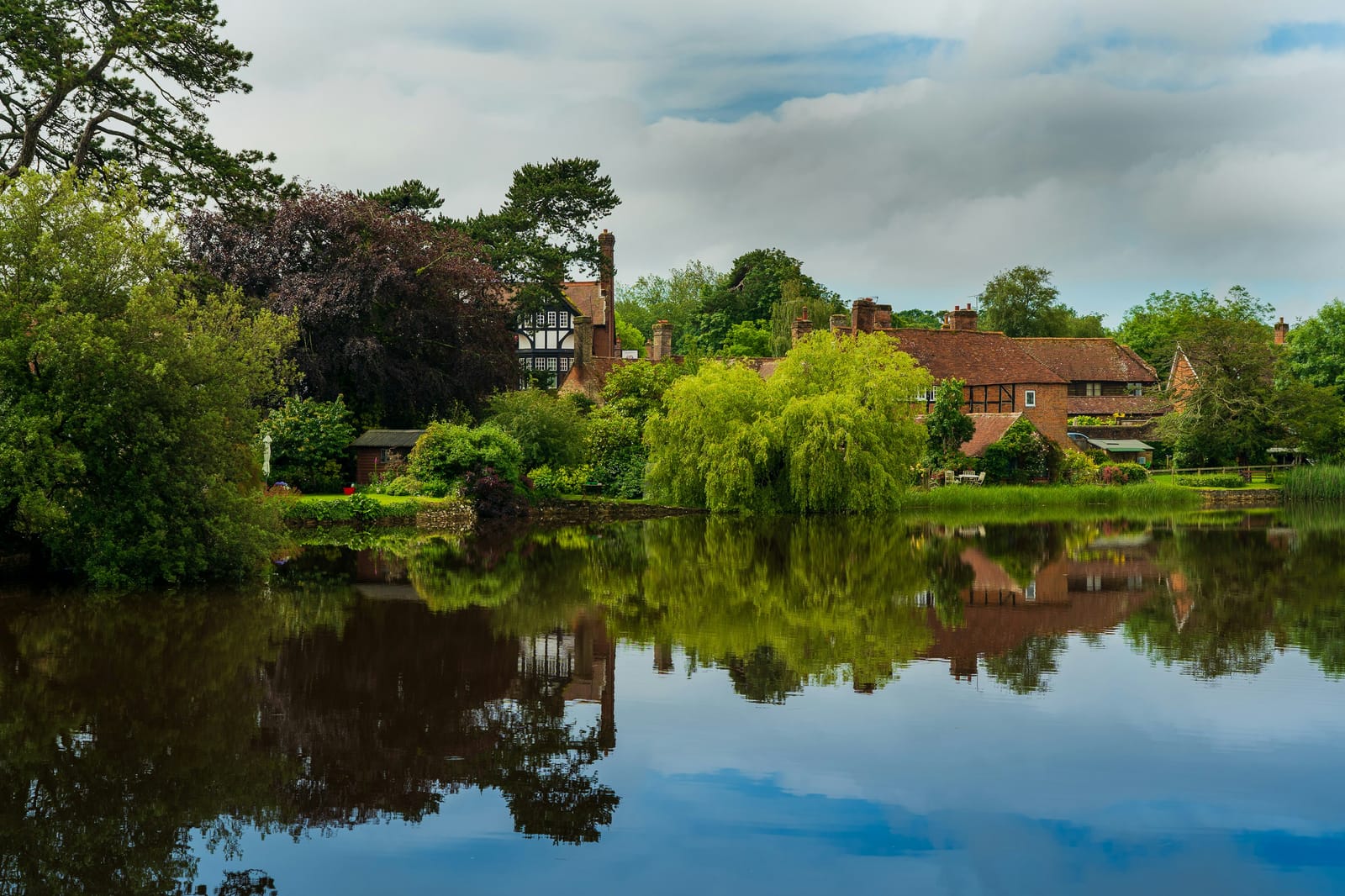 Photo of the village of Beaulieu reflected in its lake, New Forest, Hampshire.
