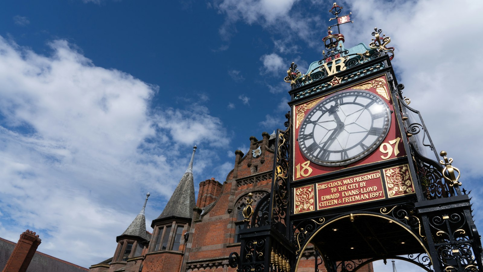 Photo of brown and white clock tower under blue sky during daytime.
