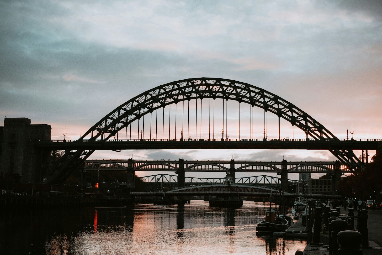 Photo of black metal bridge over body of water during daytime.