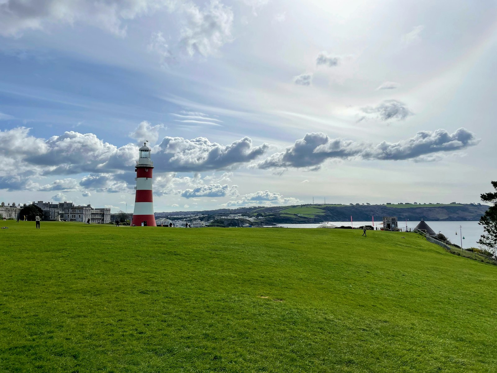 Photo of a lighthouse on a grassy hill.