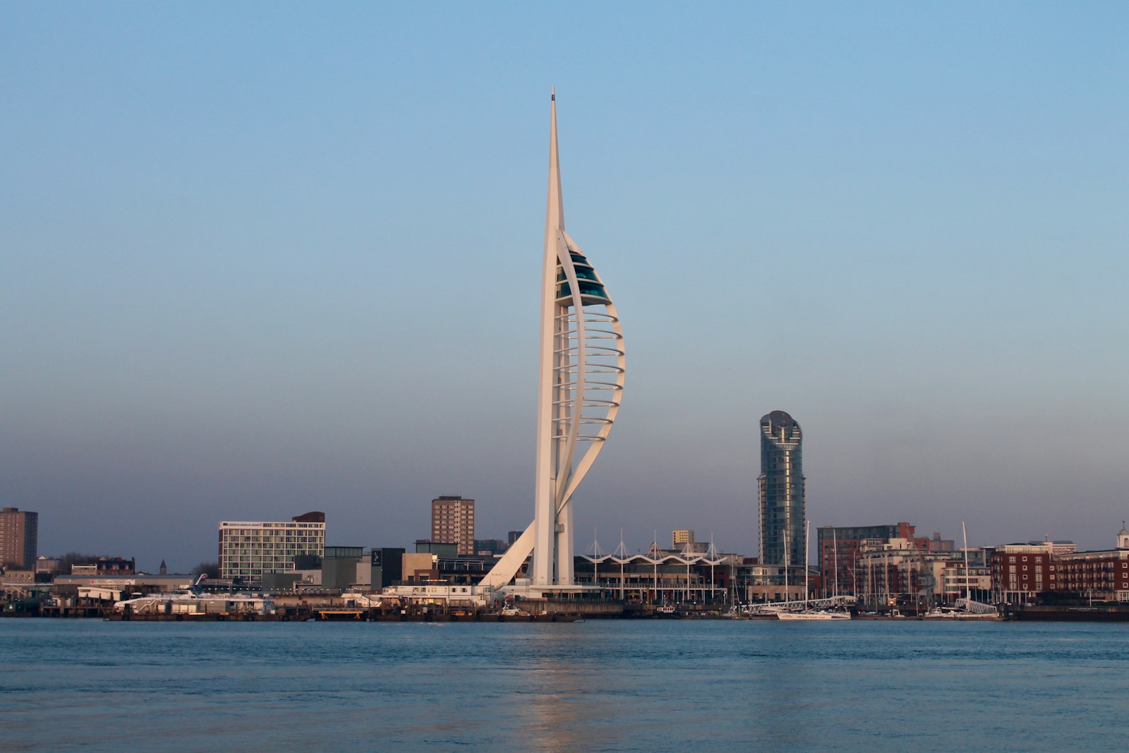 Photo of a tall white tower sitting in the middle of a body of water.